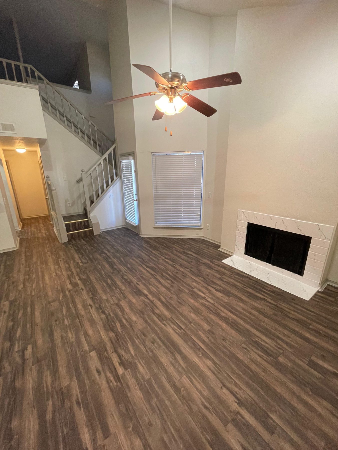 Living room with a wood-burning fireplace and ceiling fan