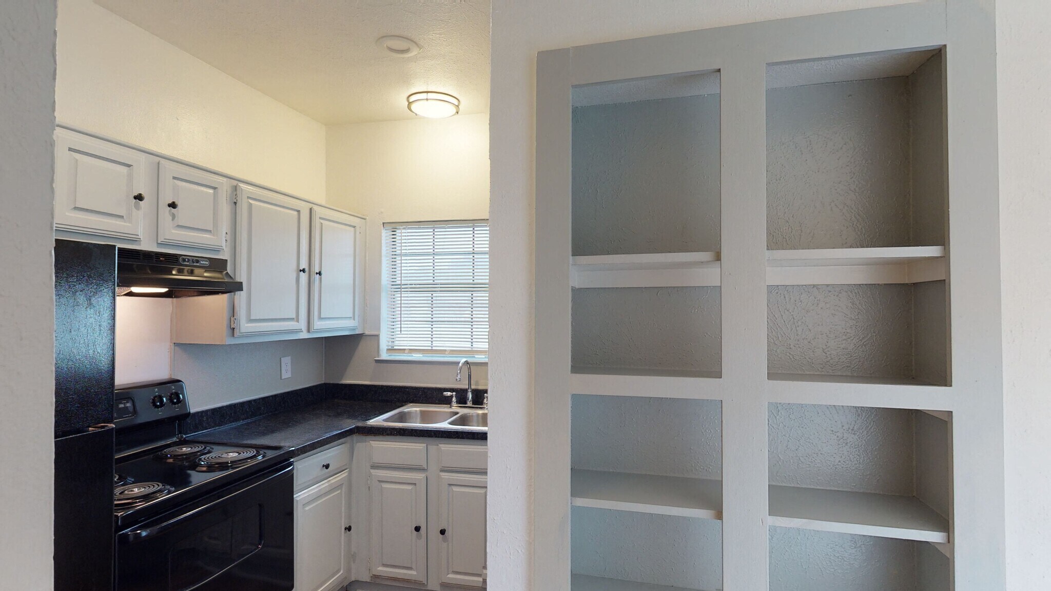 Kitchen with dark cabinets and white built-in shelving